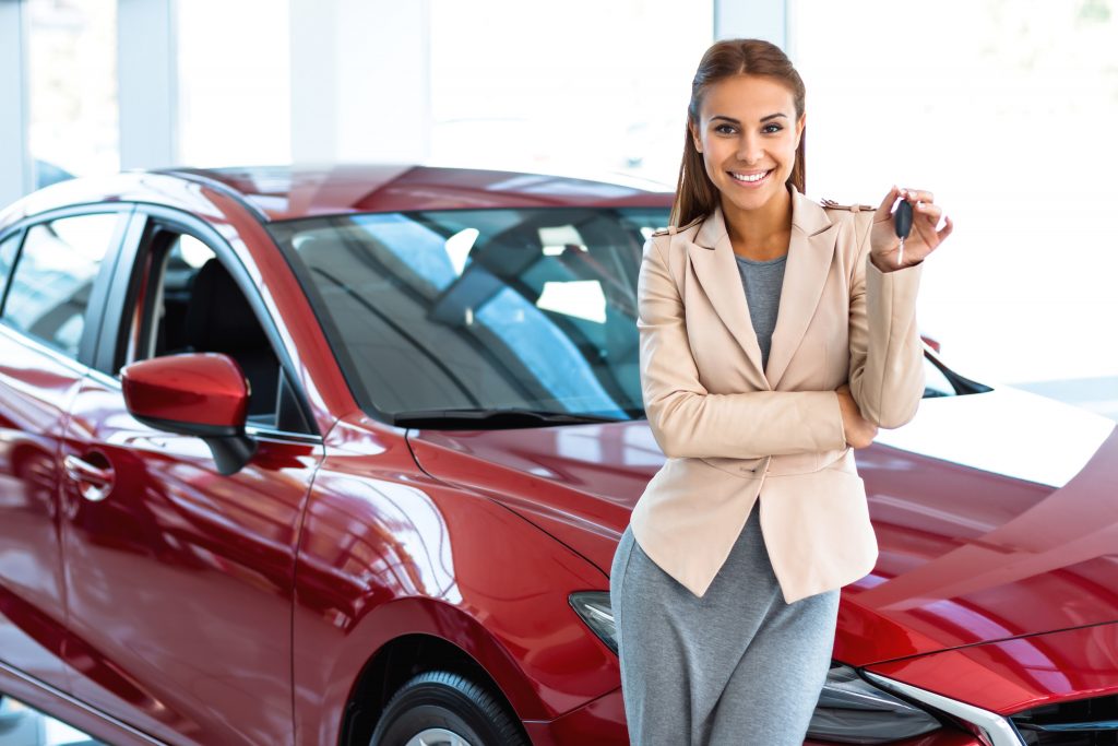 woman showing key to her new car